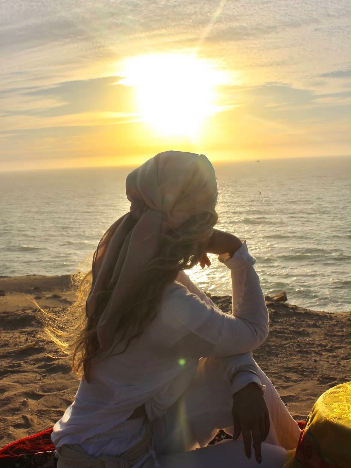 Woman watching the sunset over the Atlantic from the dunes